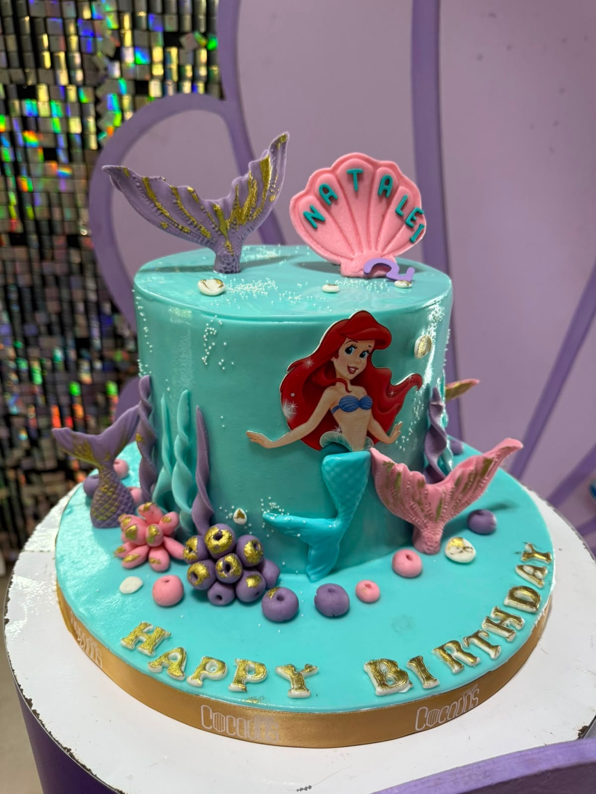 Birthday cake decorated for a mermaid theme with matching cupcakes