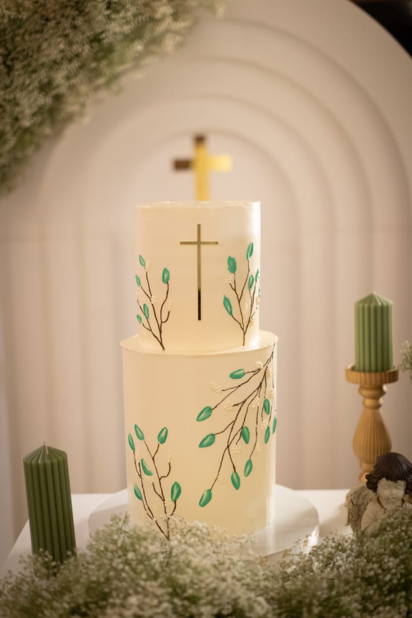 First communion cake in white with a gold cross and hand-painted leaves